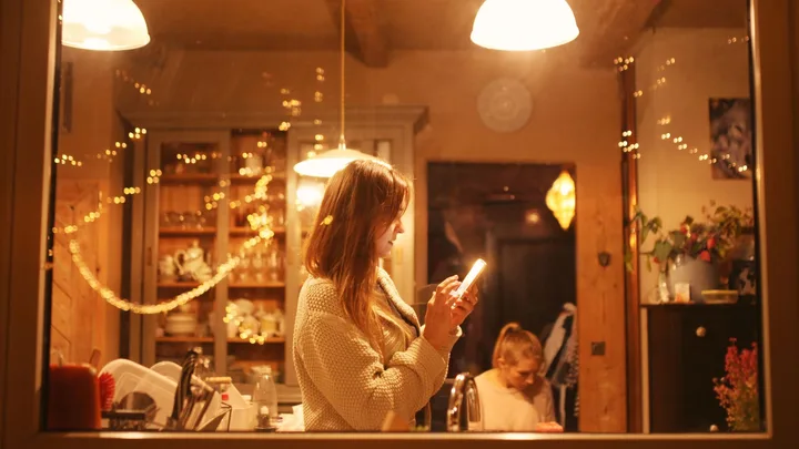 Women looking a phone in warm lit house