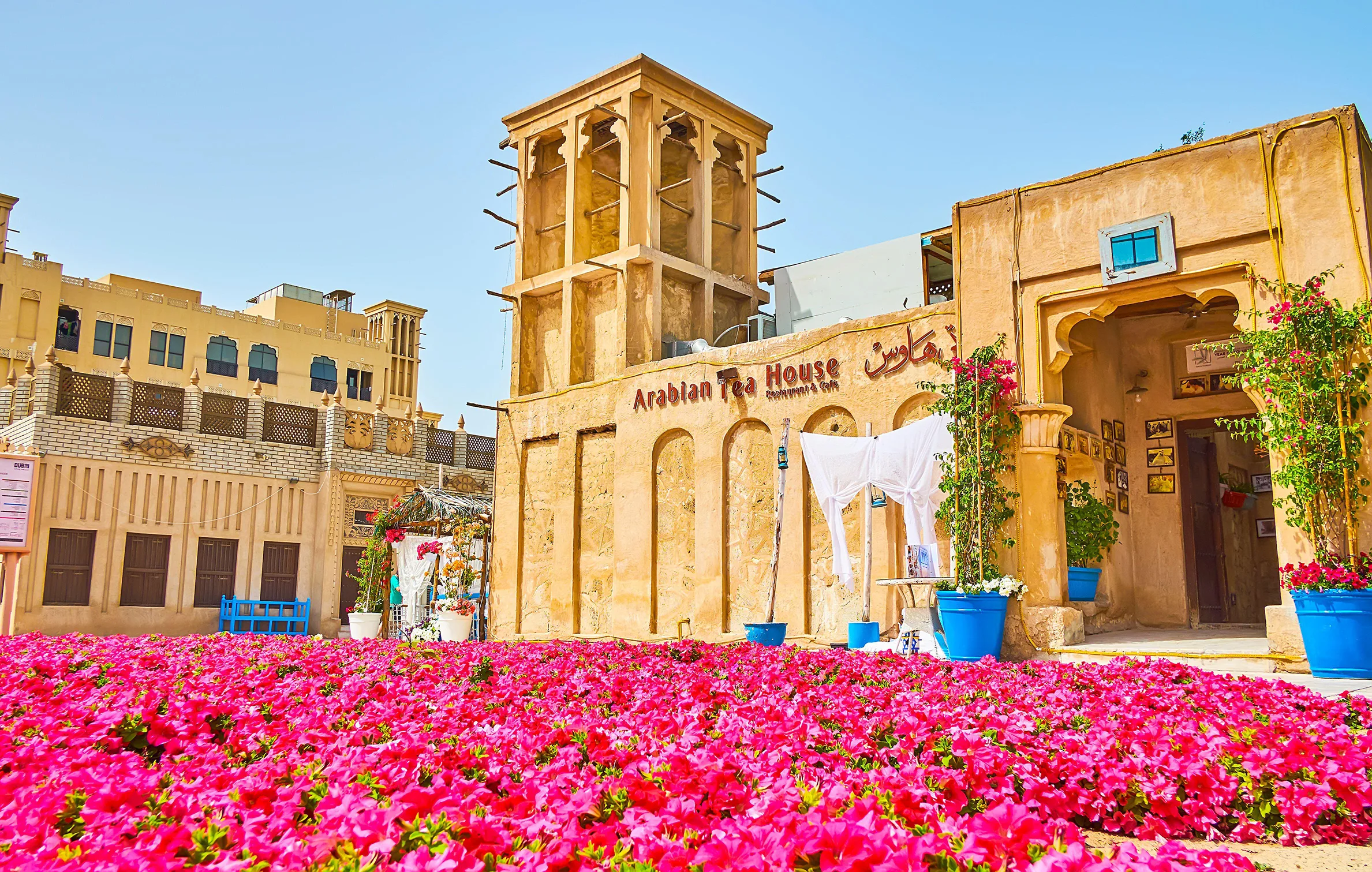 The Arabian Tea House. A sandstone building with pink flowers in front.