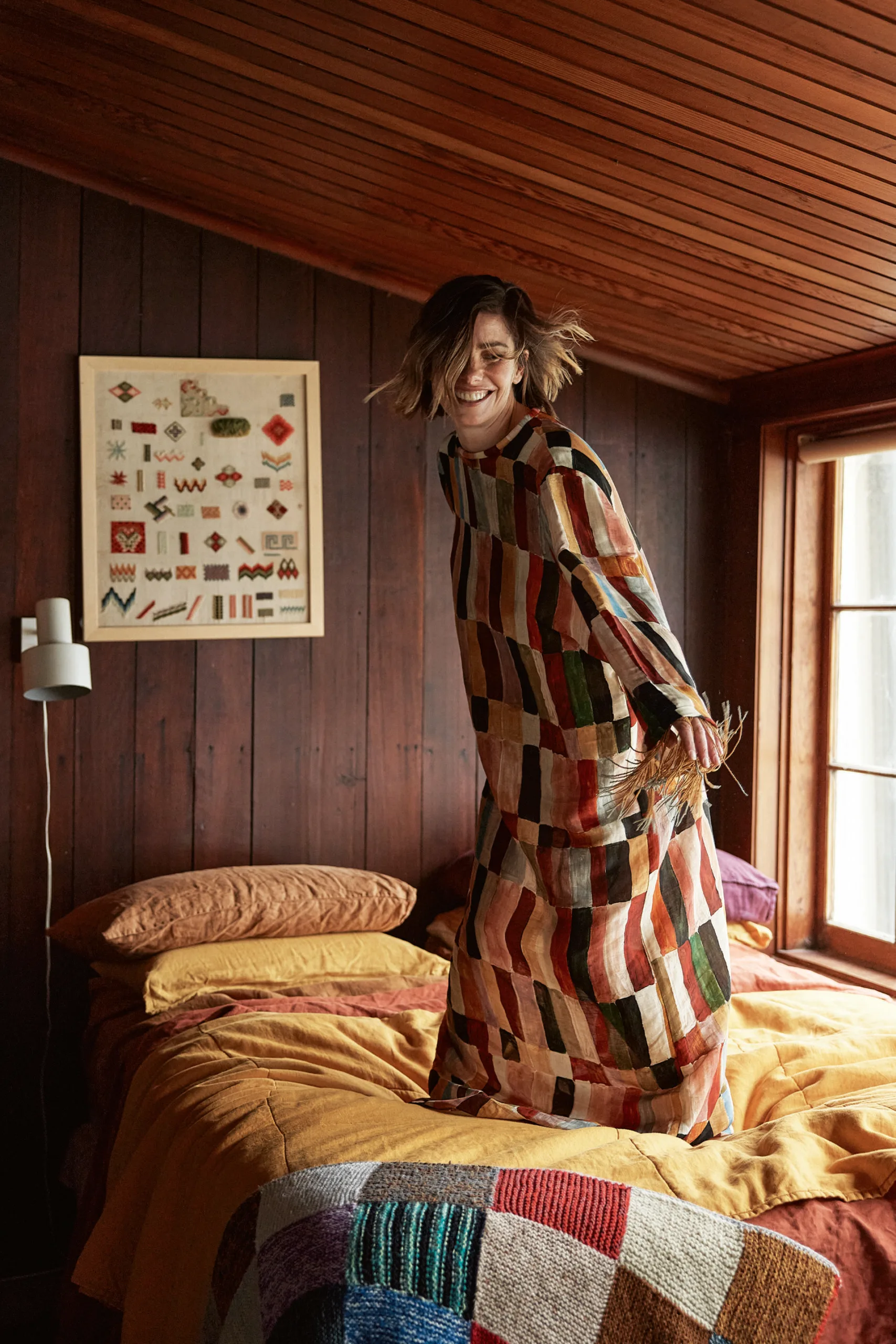 Brooke Satchwell jumping on bed. 
Photography by Corrie Bond