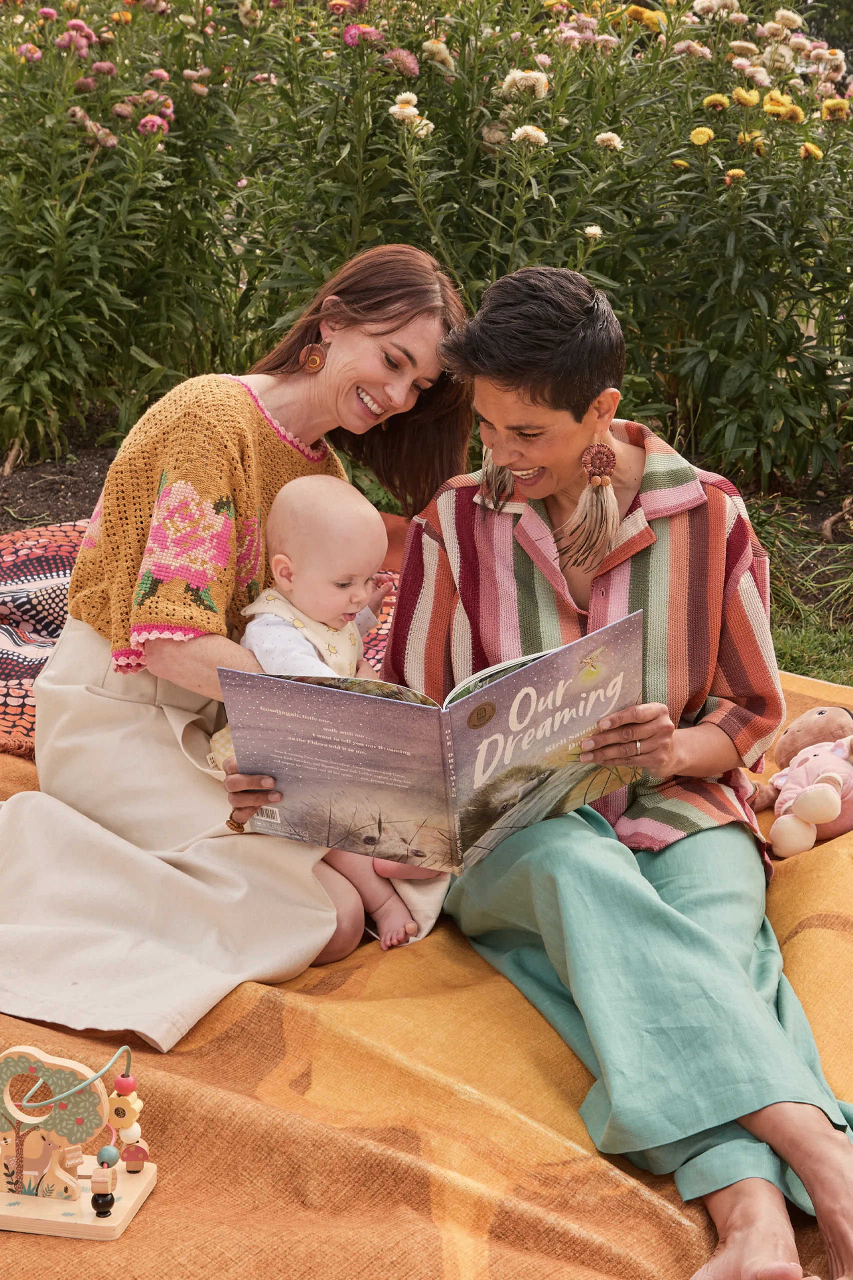 Narelda Jacobs and Karina Natt read a book to their baby Sanna. Photography by Lauren Trompp