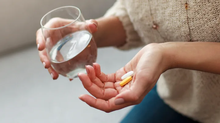 Woman vitamins pills water