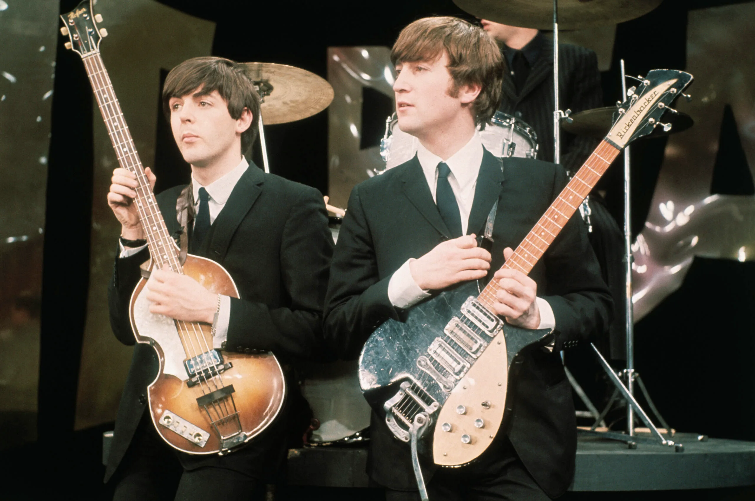 British Rock musicians Paul McCartney (left) and John Lennon (1940 - 1980), of the group the Beatles, perform on the set of 'The Ed Sullivan Show' at CBS's Studio 50, New York, New York, February 8, 1964. The photo was taken during rehearsals for the group's debut performance on the show the following day. Note that the backdrop was very different from the one used in the broadcast. (Photo by UPI/Bettmann via Getty Images)