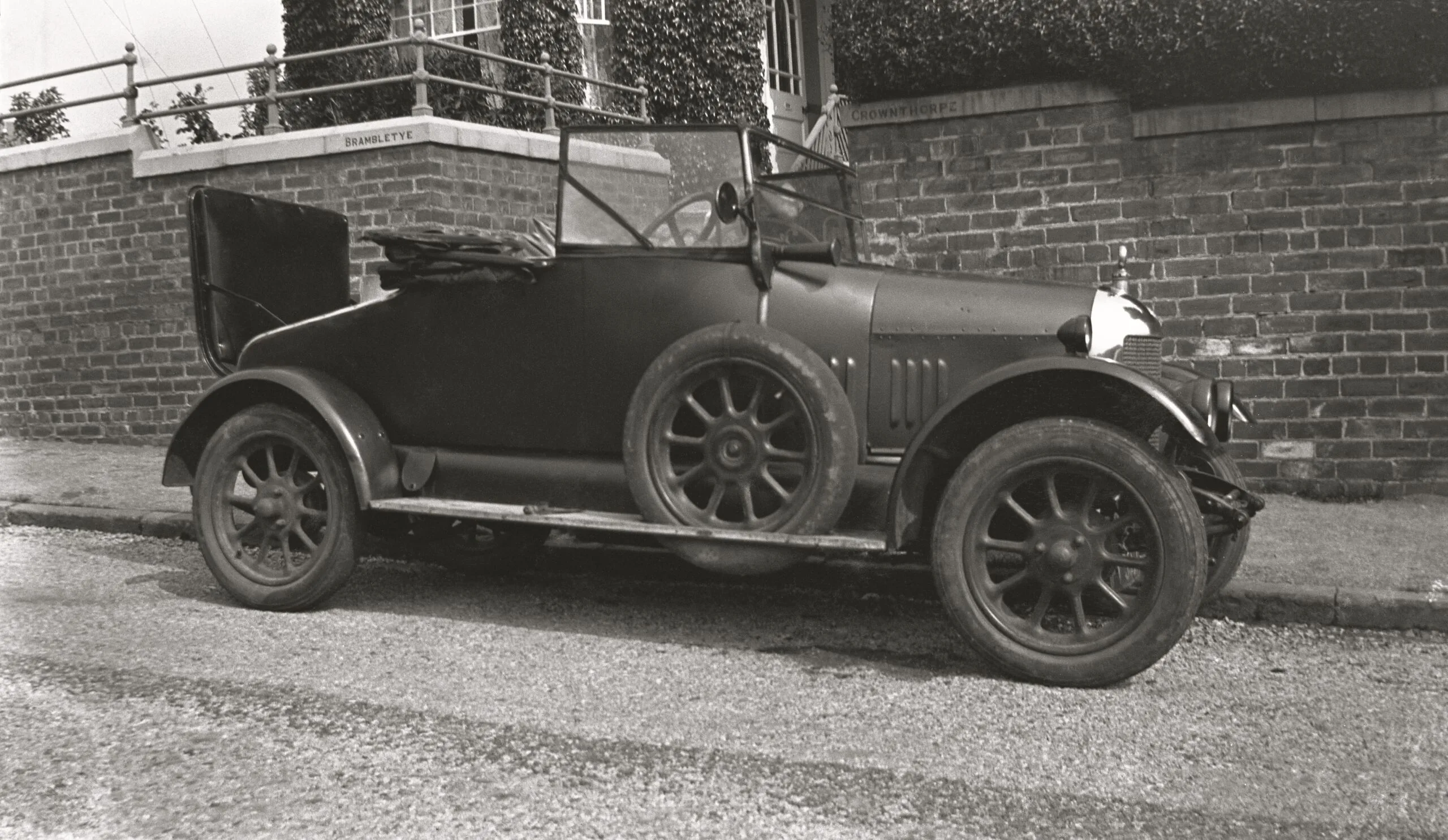 Woman sitting in Morris Cowley Bullnose motorcar parked on street beside house, England circa 1924. (Photo by The Montifraulo Collection/Getty Images)