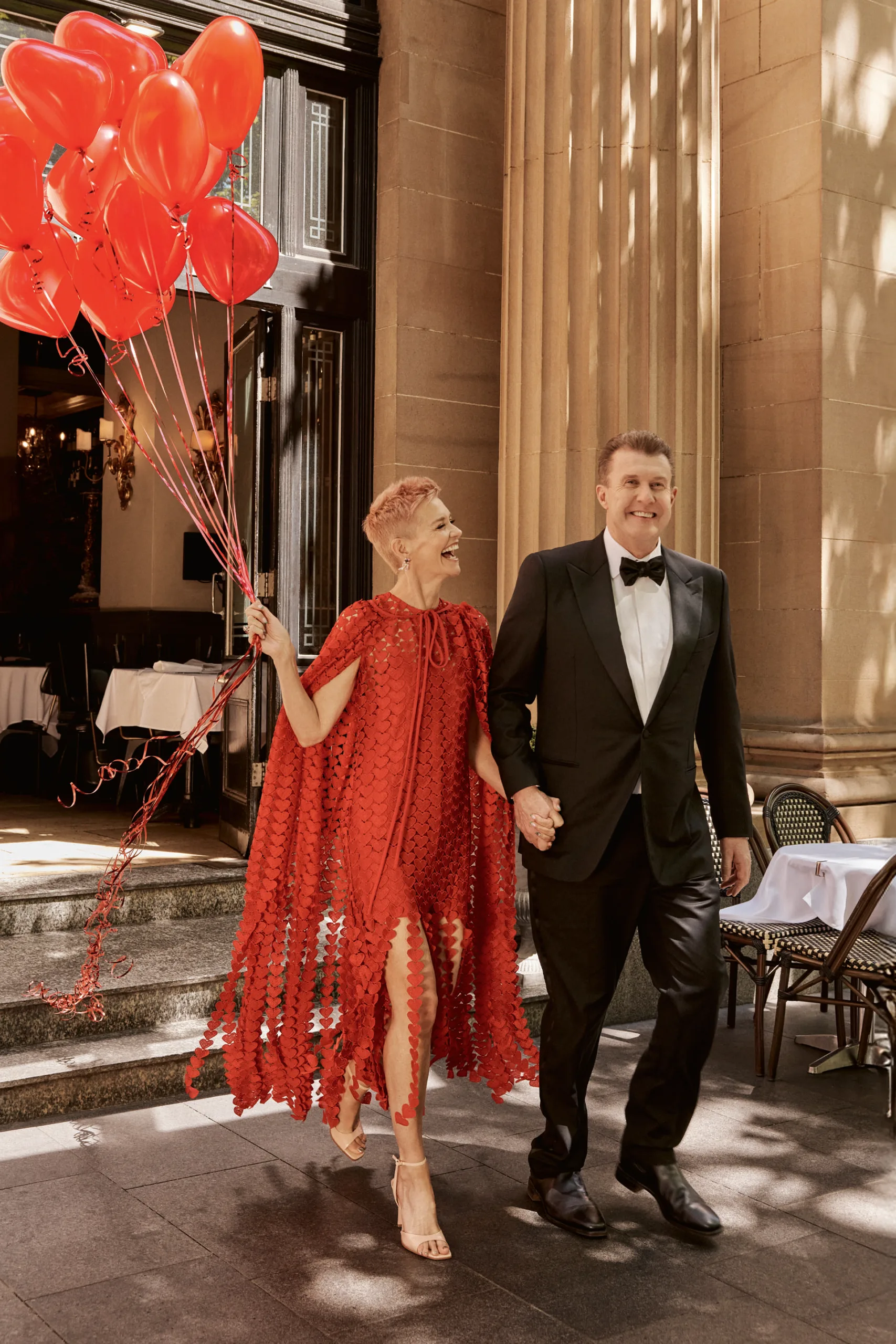 Jessica Rowe and Peter Overton holding balloons and walking down the street. Photography by Corrie Bond.