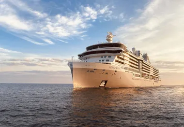 A cruise ship on a calm sea at sunset