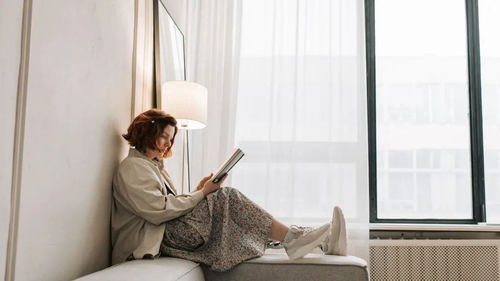 woman reading a book on a couch