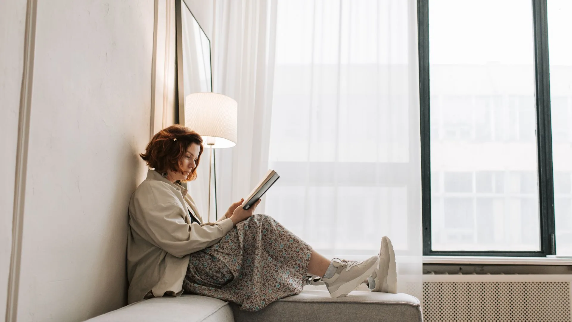 woman reading a book on a couch