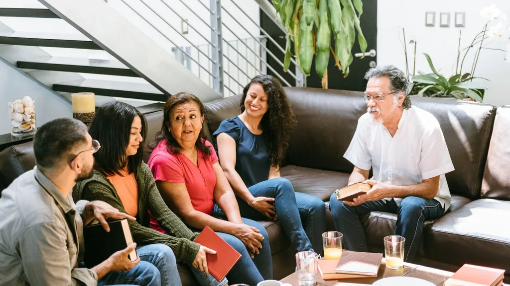 Five people sitting on a couch in a book club.