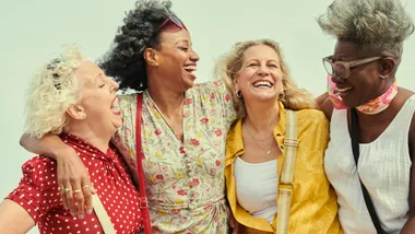 four mature women laughing
