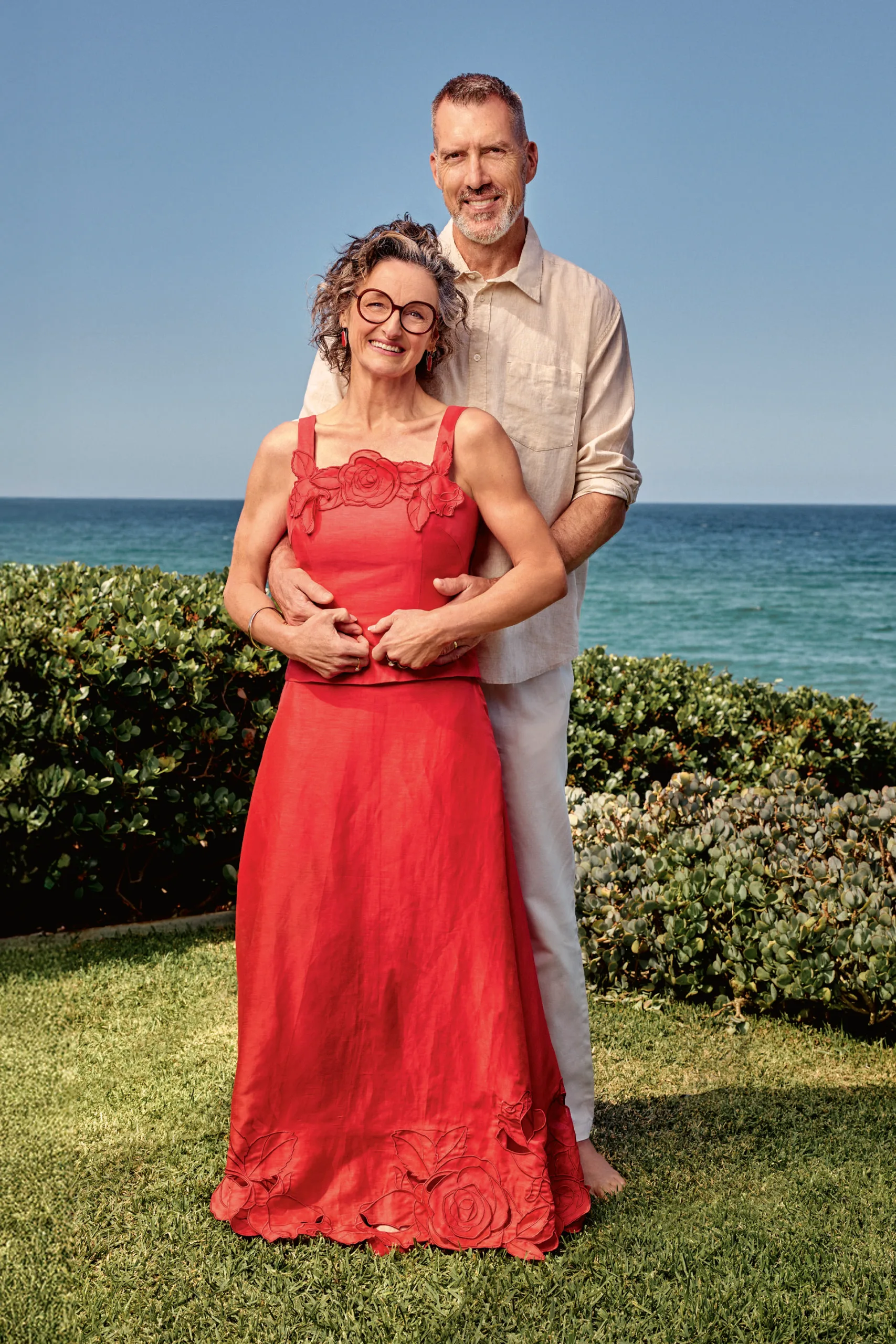 Julie and Mick Goodwin posing in front of the sea. Photography by Peter Brew-Bevan.