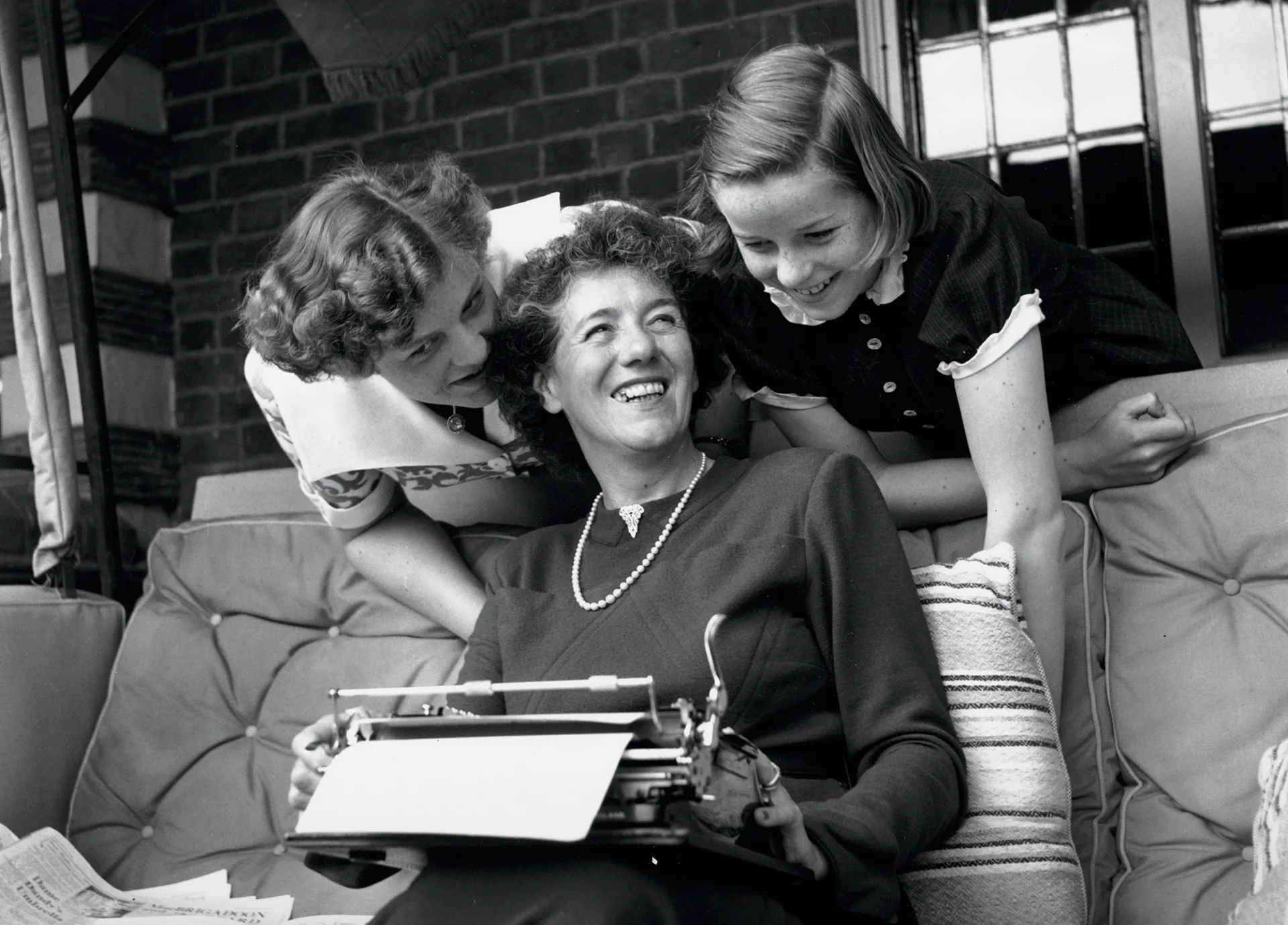 1949:  The famous children's author Enid Blyton with her two daughters Gillian (left) and Imogen (right) at their home in Beaconsfield, Buckinghamshire.  (Photo by George Konig/Keystone Features/Getty Images)