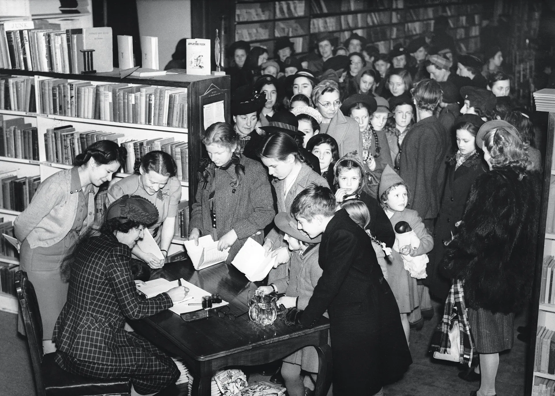 Enid Blyton (1897-1968) the children's author, signs autographs for queues of waiting fans in a Brompton Store, London. She is popular for among others, her adventure and mystery stories such as the Famous Five series. (Photo by &copy; Hulton-Deutsch Collection/CORBIS/Corbis via Getty Images)