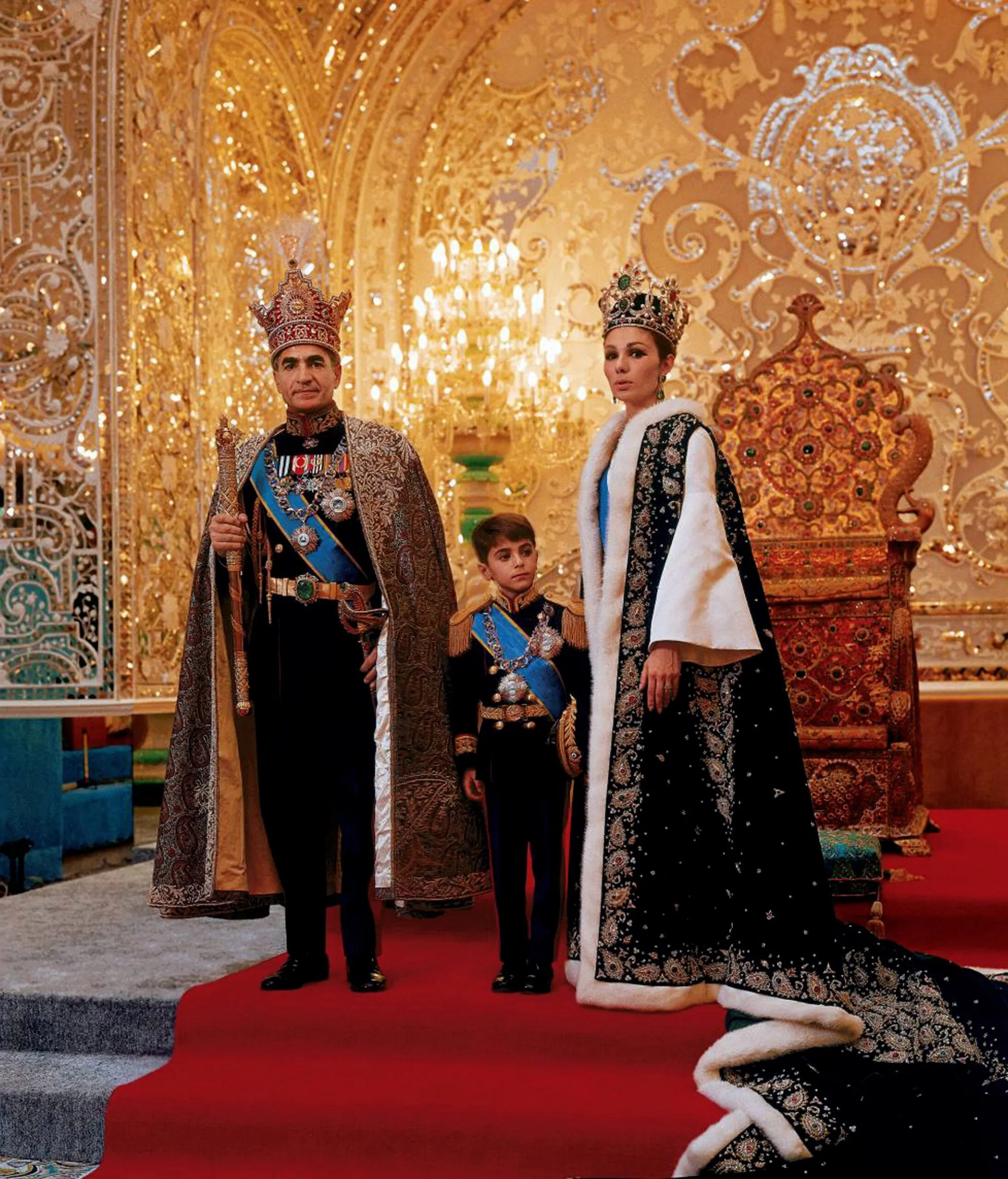 UNSPECIFIED - CIRCA 1754: Mohammed Reza Shah Pahlavi (1919-1980) Shah of Iran 1941-1979, with his third wife Farah Diba and their son Reza in ceremonial dress in front of throne. (Photo by Universal History Archive/Getty Images)