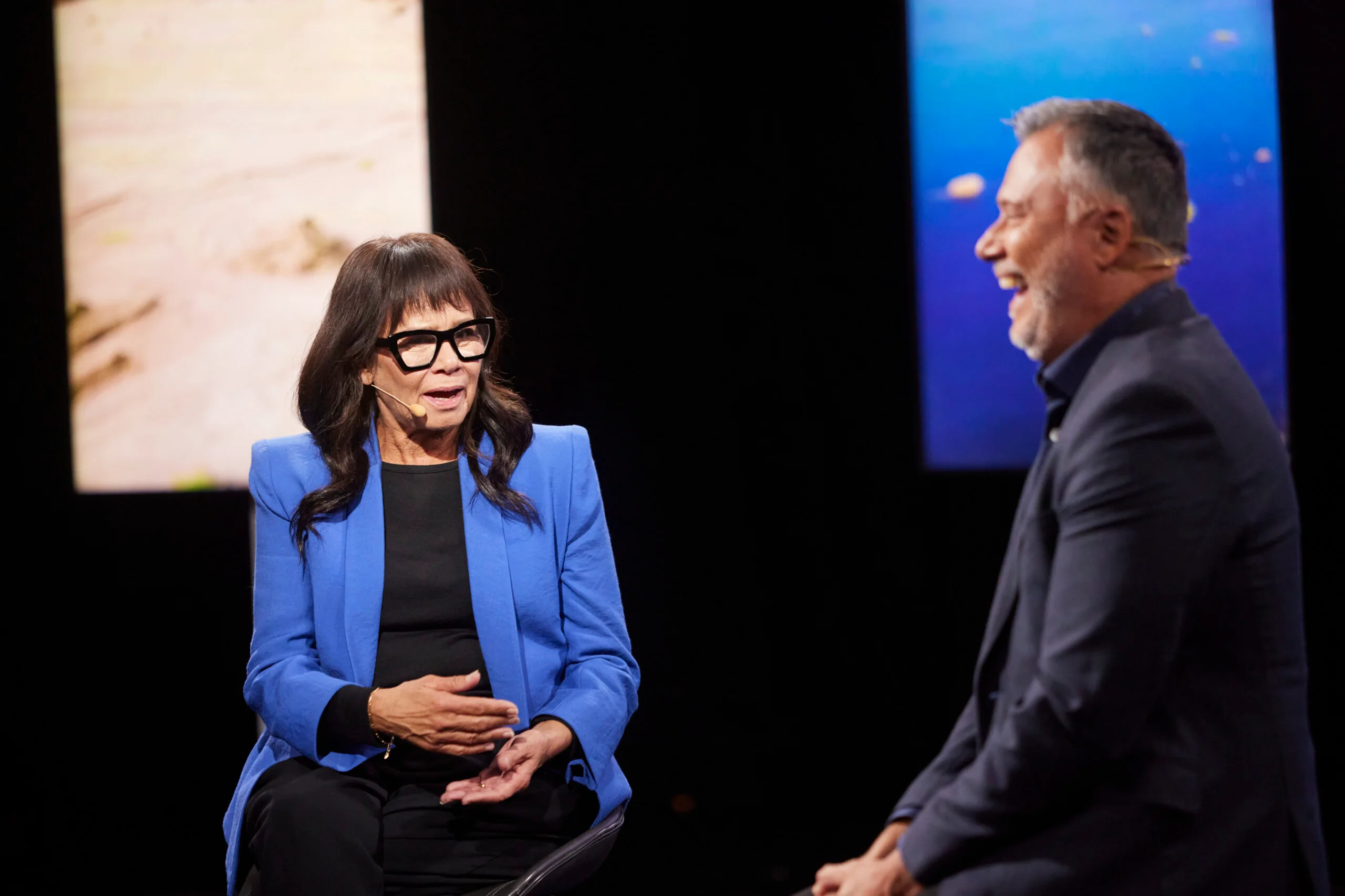 Rhoda Roberts on a stage with journalist Stan Grant, who is laughing.