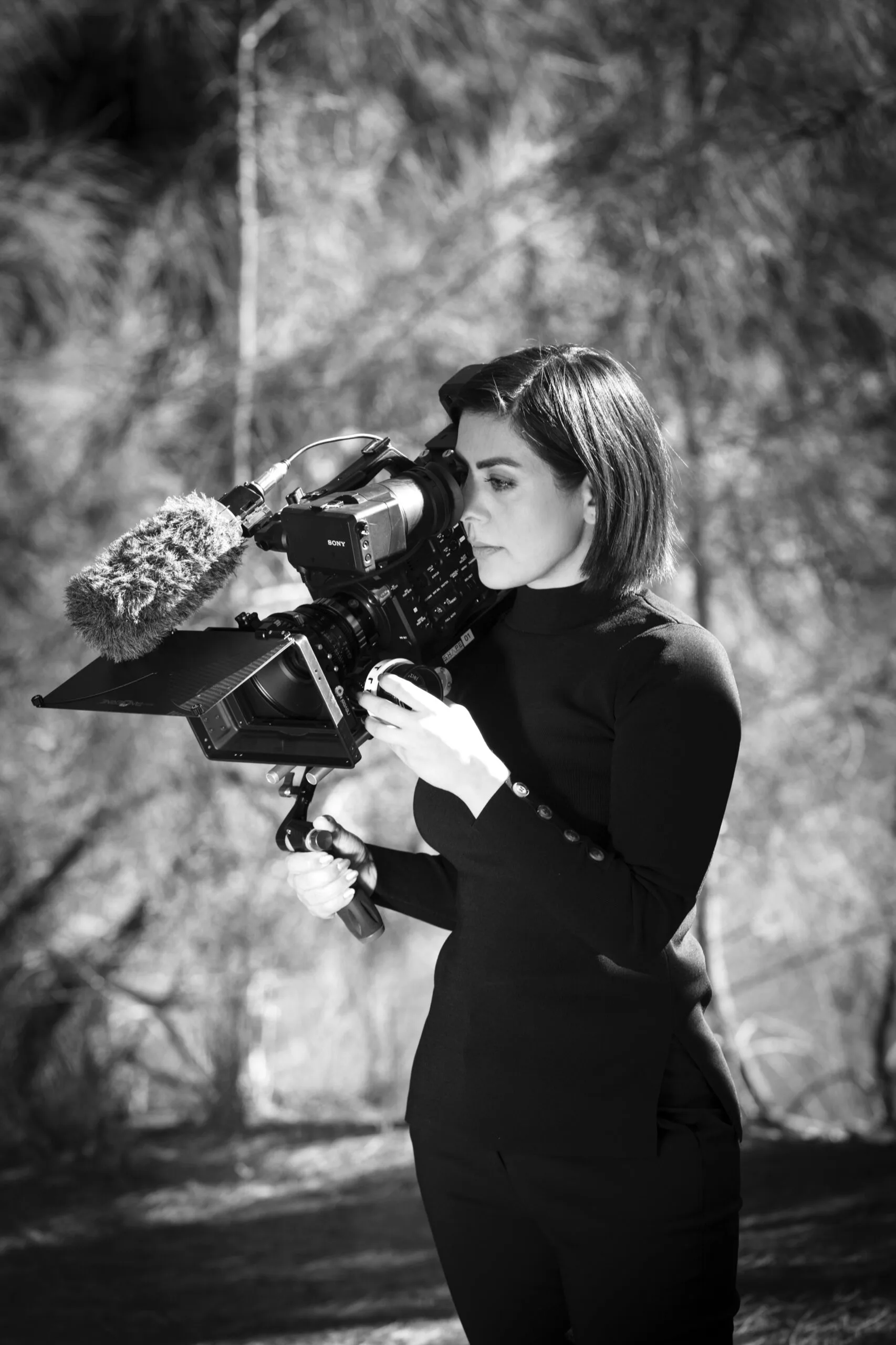 A black and white portrait of Saba with a video camera.