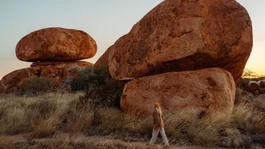 Woman walking past rock formations in the Northern Territory