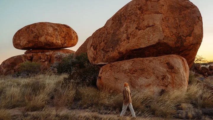 Woman walking past rock formations in the Northern Territory