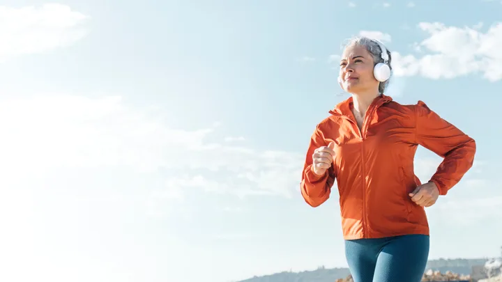 older woman running with headphones