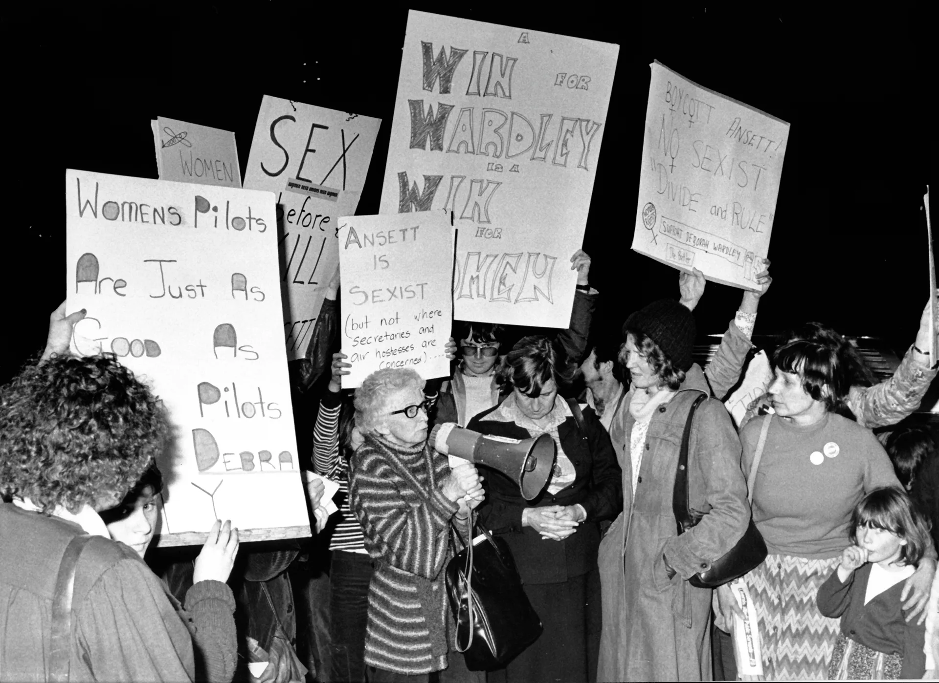 The Women's Electoral Lobby demonstrates outside the Ansett building in Melbourne. Signs read: 'Ansett is sexist (but not where secretaries and air hostesses are concerned)', 'Women pilots are just as good as...', 'Boycott Ansett! No sexist divide and rule'. File (Melb) G: Aust: Disorders & Demos: Women Date Filed: 02-08-1979 Neg No: H 28787 / 9 ID: ajb
