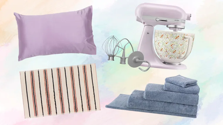 A product collage of home and kitchen gift ideas, featuring a lilac silk pillowcase, a pastel purple KitchenAid stand mixer with a floral ceramic bowl, a striped cream bath mat, and a stack of ribbed blue towels on a pastel watercolour background.