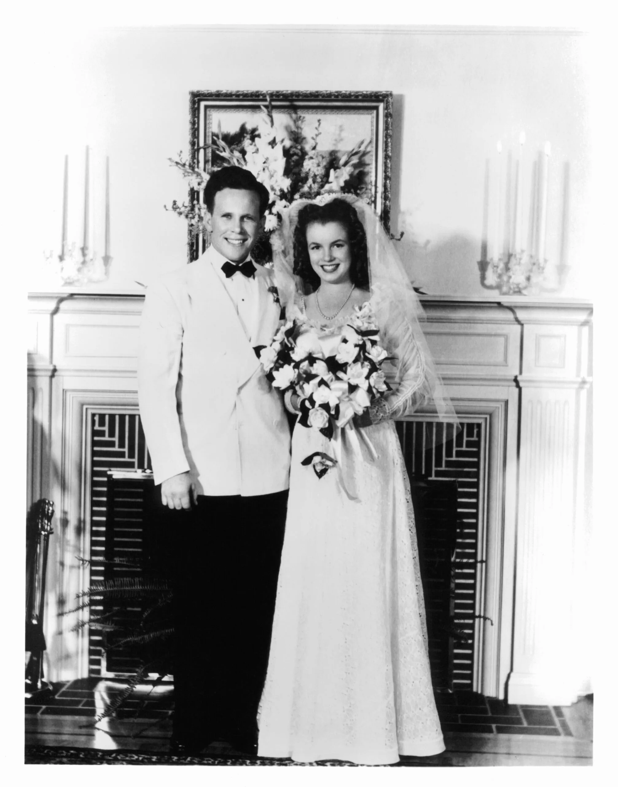 James Dougherty and Marilyn Monroe on their wedding day in Los Angeles being photographed in front of a fireplace 1942. (Photo by Getty Images)