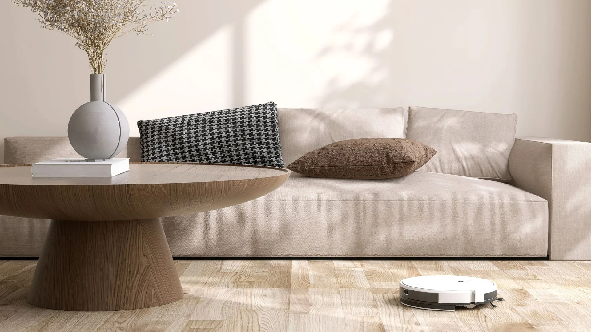 A white robot vacuum cleaning a light timber floor in a modern, minimalist living room.