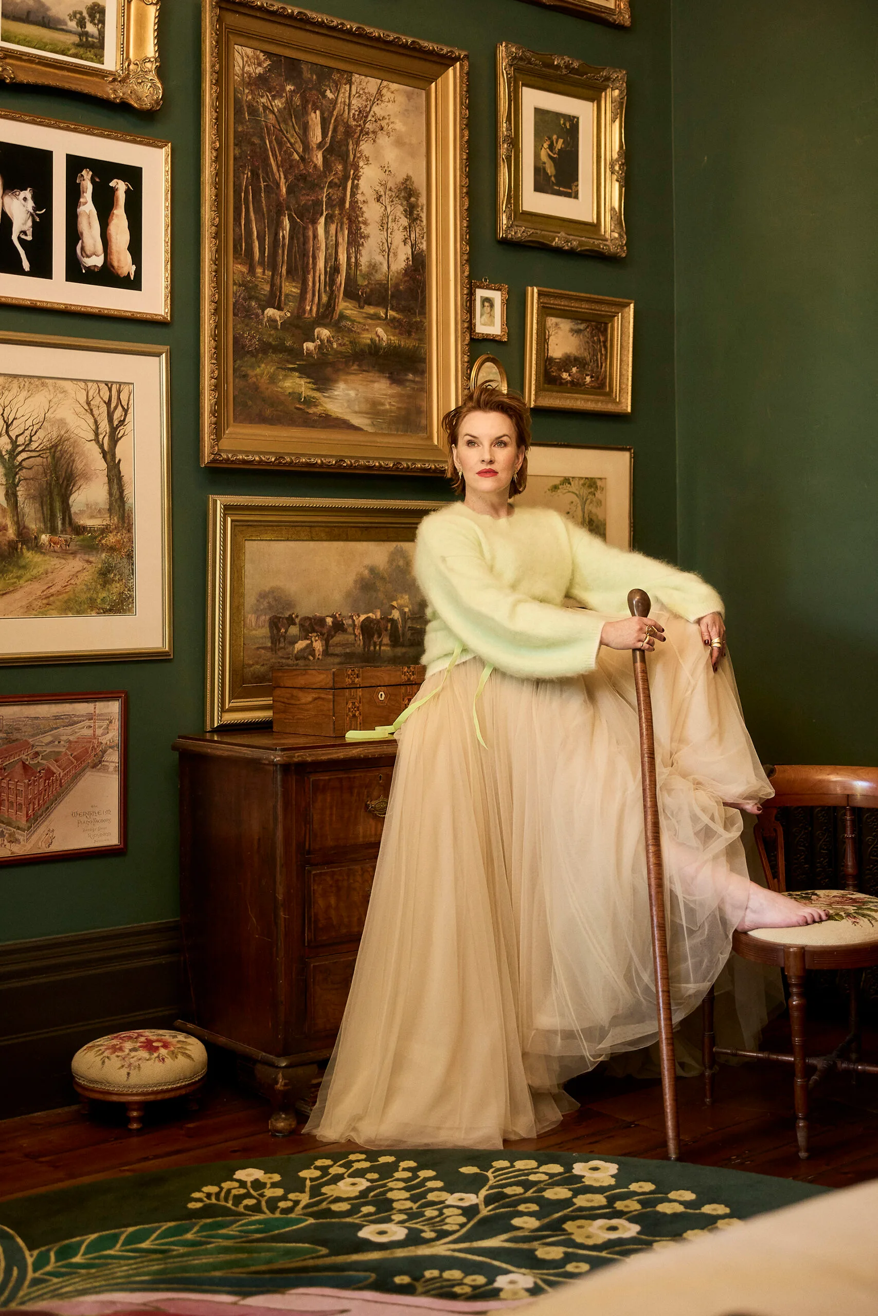 Kate Mulvany sitting on a sideboard, using a cane. Photo by Peter Brew-Bevan