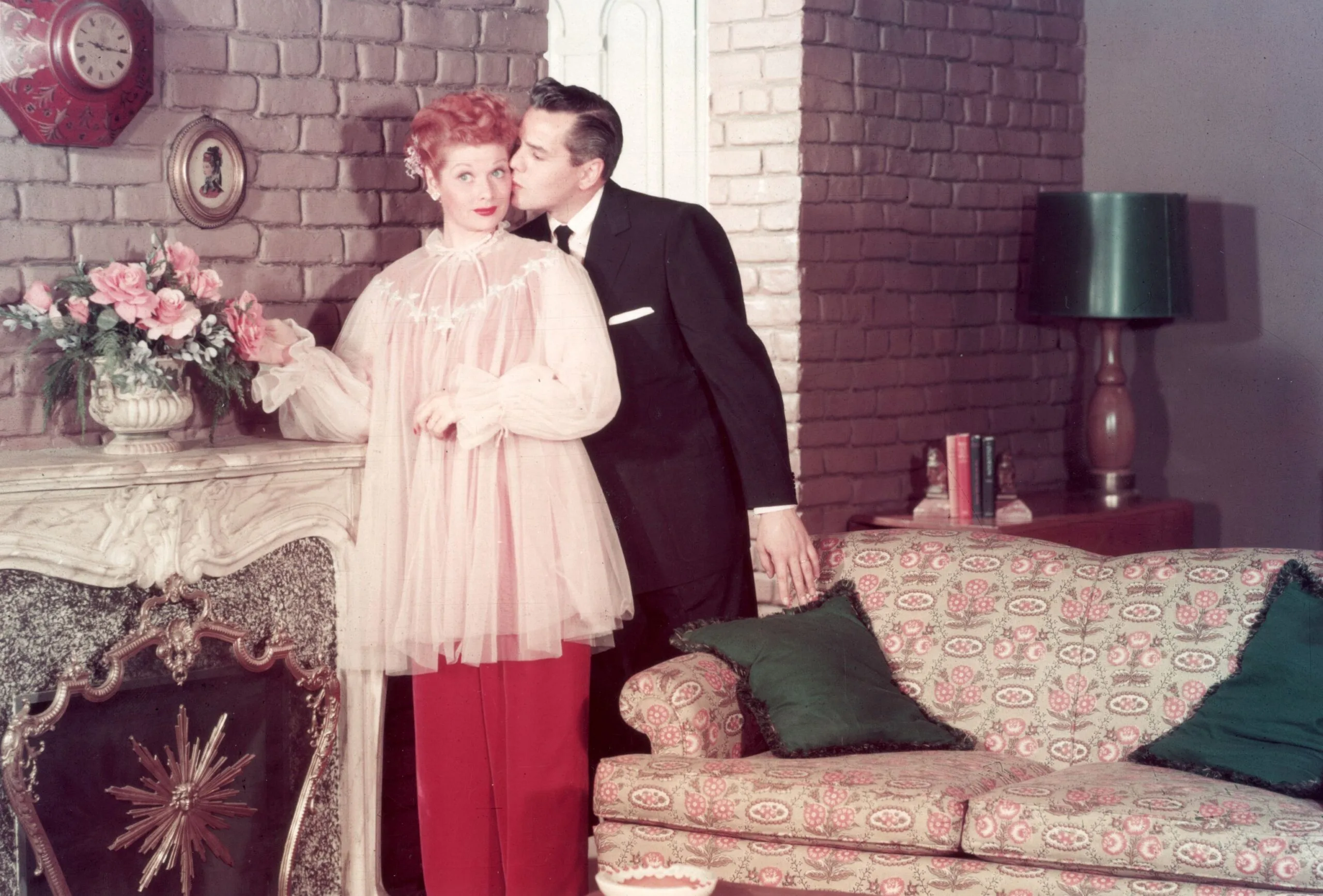 circa 1955: American actor and comedian Lucille Ball receives a kiss on the cheek from her husband, Cuban-born bandleader and musician Desi Arnaz, on the set of their television series, 'I Love Lucy'. (Photo by CBS Photo Archive/Getty Images)

