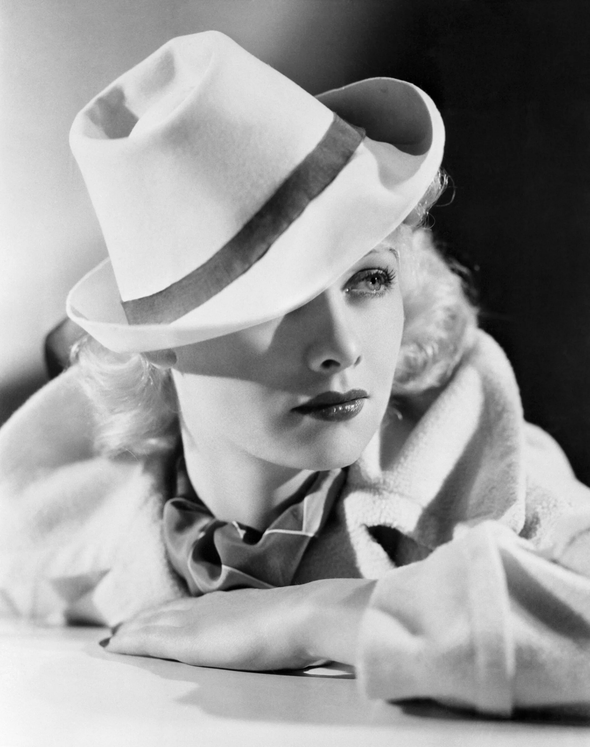(Original Caption) Lucille Ball, Warner Bros. player, wears the "gondolier" hat, newest Hollywood fashion inspired by a Hollywood production, Top Hat, in which reproductions of the famous Italian Lido, including canals, gondolas and the gondoliers were filmed. This one is made of white felt banded in a blue grosgrain ribbon.