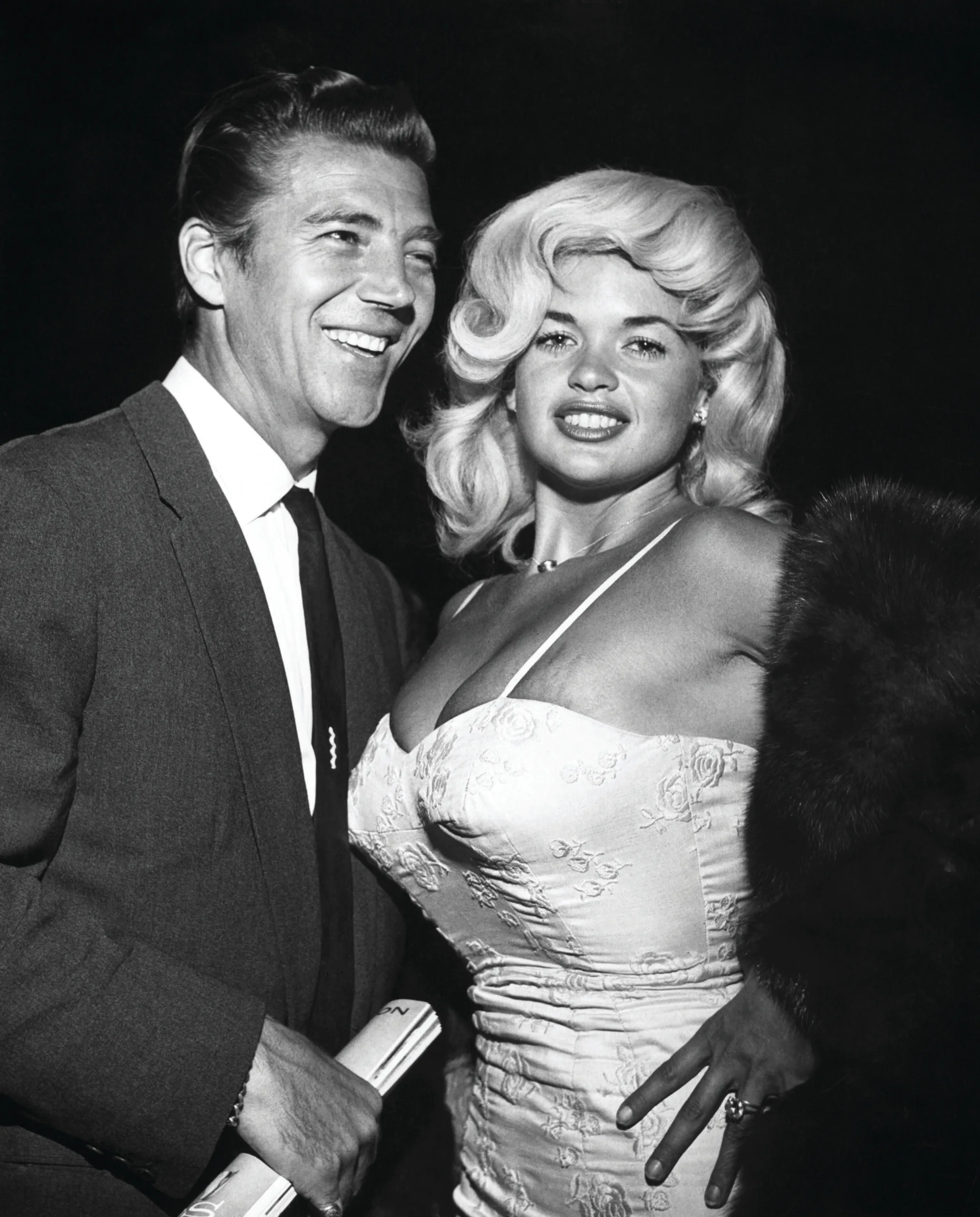(Original Caption) Jayne Mansfield's fans got a chance recently to compare their favorite with blonde (her own) and dark (a most attractive wig) hair. The popular fad of changing one's hair color at the merest whim can now be indulged in providing milady has sufficient money - and Jayne has! She showed up at a recent Hollywood affair as a blonde, but later in the evening emerged from the powder room as a brunette. Hubby Mickey Hargitay seems to be pleased, either way. Undated photograph.
