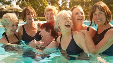 women in pool laughing