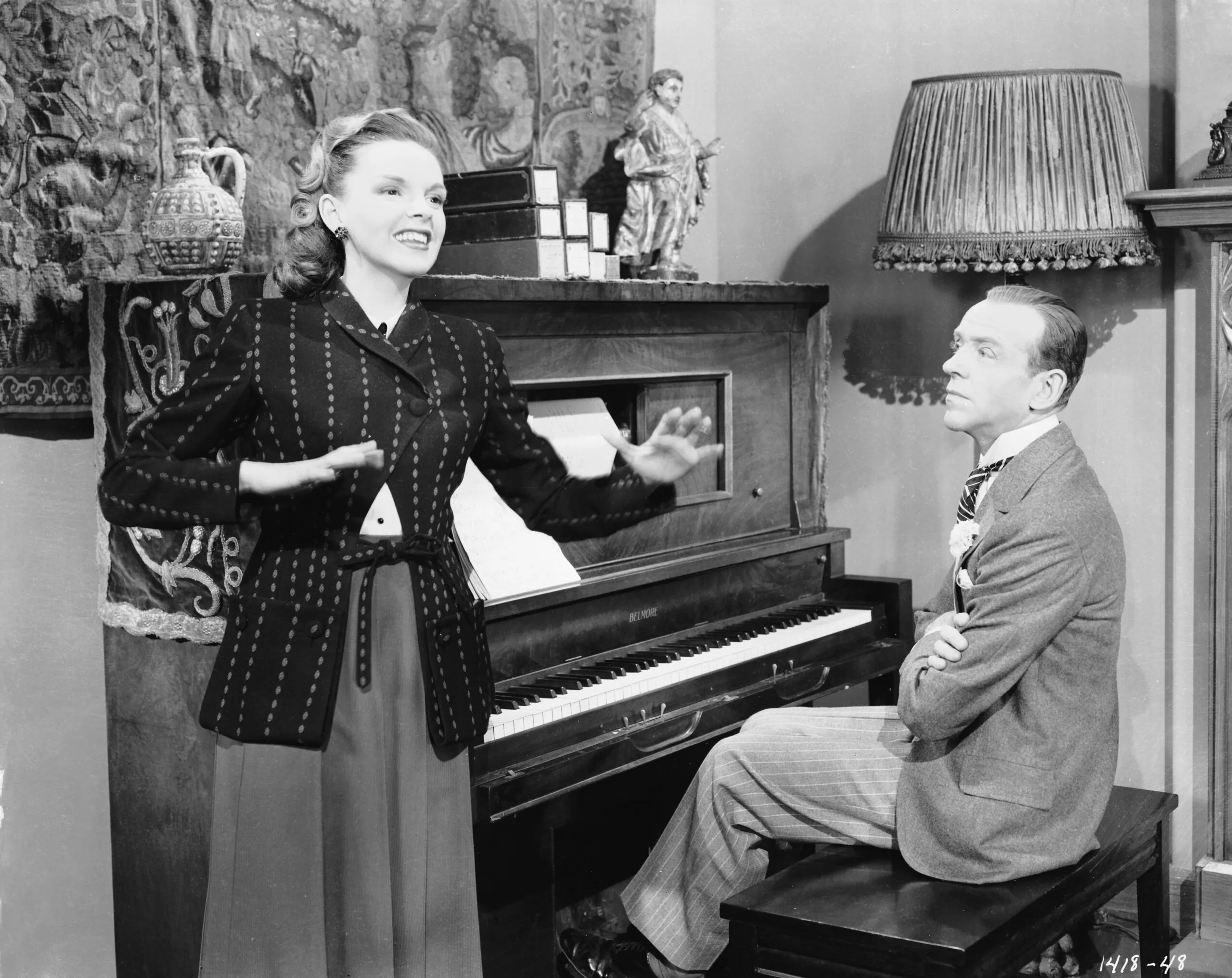 Fred Astaire (1899 - 1987) enjoys a private performance from Judy Garland (1922 - 1969) in a scene from the MGM film 'Easter Parade', directed by Charles Walters, 5th January 1948. (Photo via John Kobal Foundation/Hulton Archive/Getty Images)