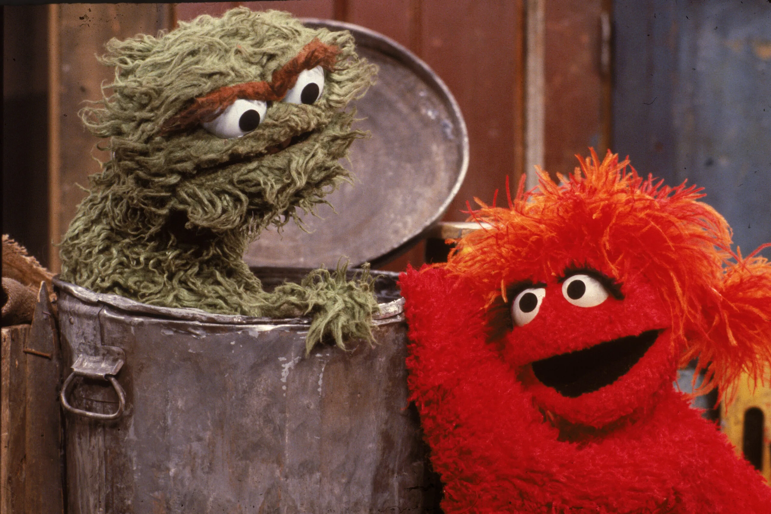A muppet visits 'Oscar the Grouch' at his garbage can in a scene from 'Sesame Street,' circa 1985. (Photo by Children's Television Workshop/Courtesy of Getty Images)