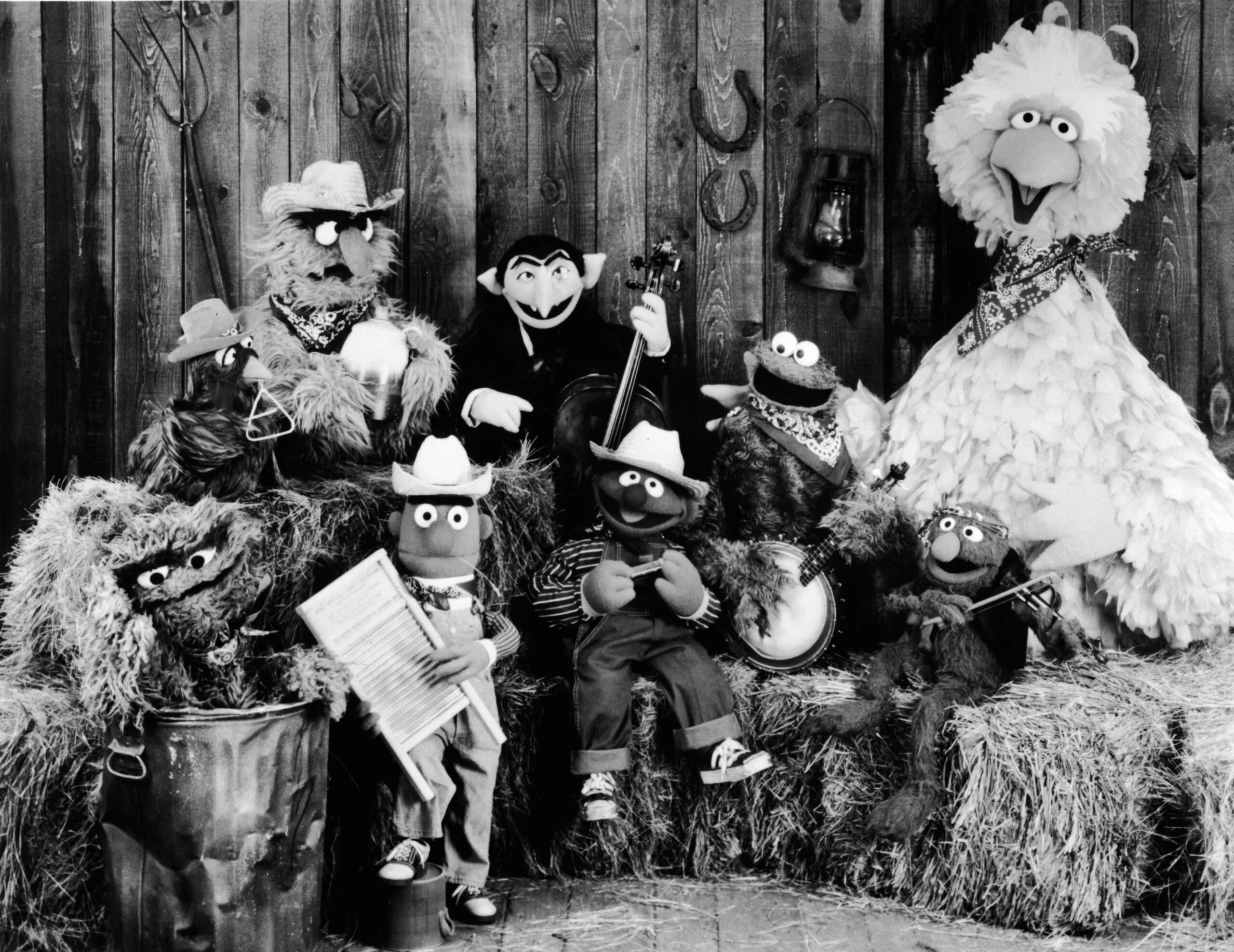Publicity still of the 'Sesame Street' muppets including 'Oscar the Crouch' (in garbage can), 'Bert' (holding washboard), 'Ernie' (harmonica), 'the Count' (bass), 'Cookie Monster' (banjo), 'Grover' (violin), and 'Big Bird' (far right), promoting their album 'Sesame Country', July 1st 1981. (Photo by Children's Television Workshop/Courtesy of Getty Images)