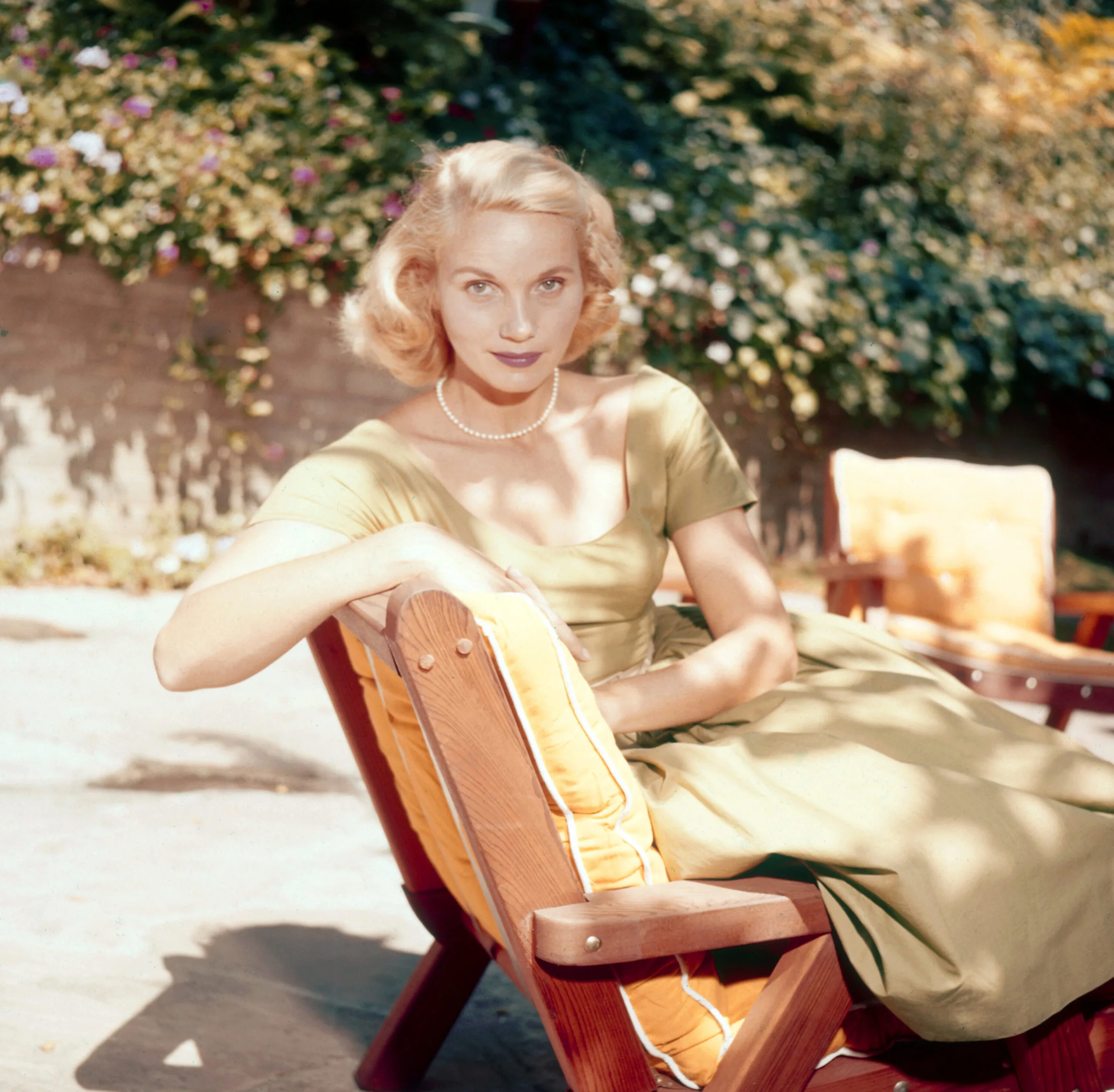 Actress Eva Marie Saint pictured seated on a sun lounger in a garden, USA, circa 1950. Saint is wearing a light green dress and a pearl necklace. (Photo by Archive Photos/Getty Images)