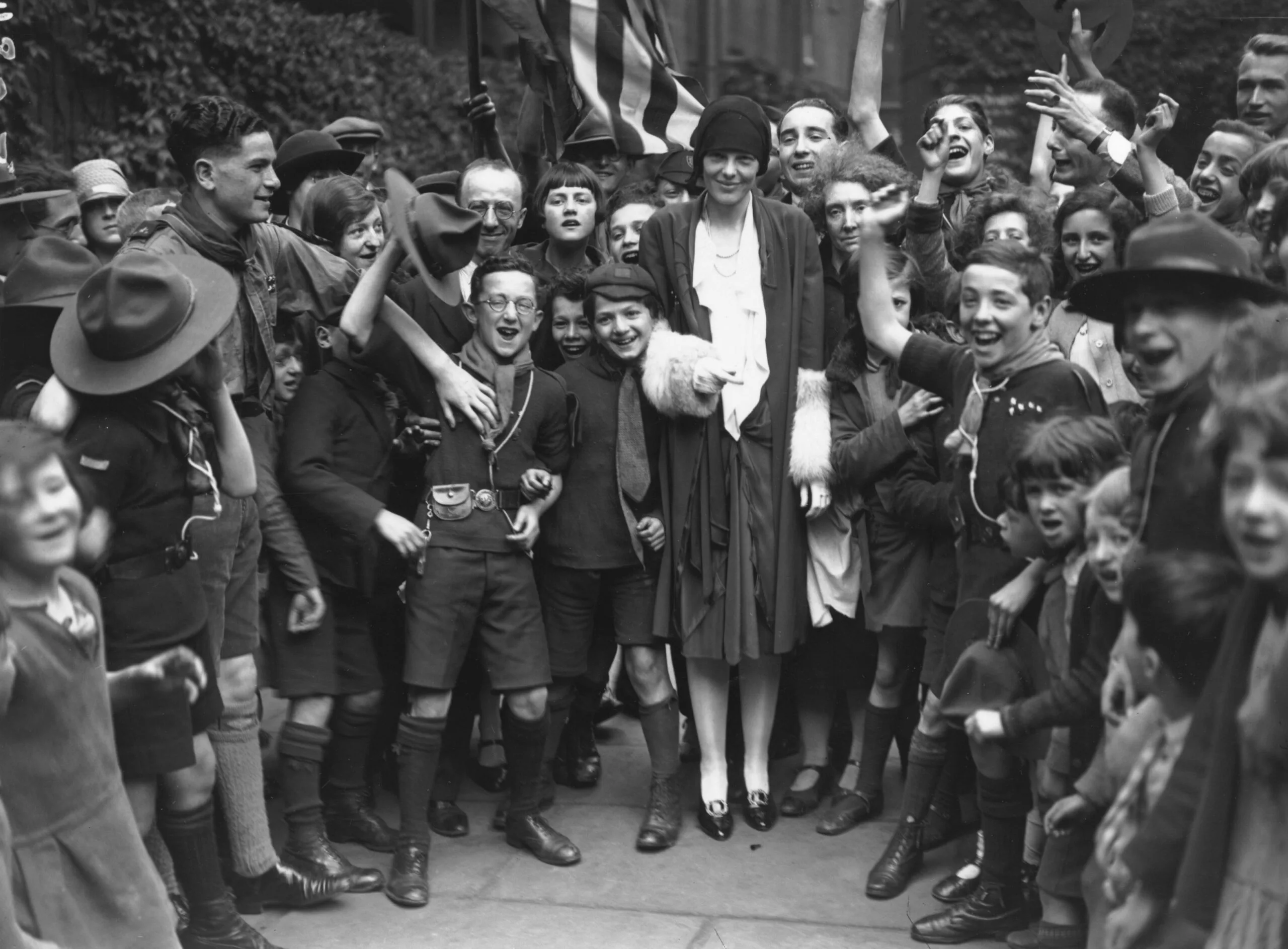 22nd June 1928: American aviatrix, Amelia Earhart (1898 - 1937), being cheered by the children in the East End during her visit to Toynbee Hall, London. (Photo by J. Gaiger/Topical Press Agency/Getty Images)
