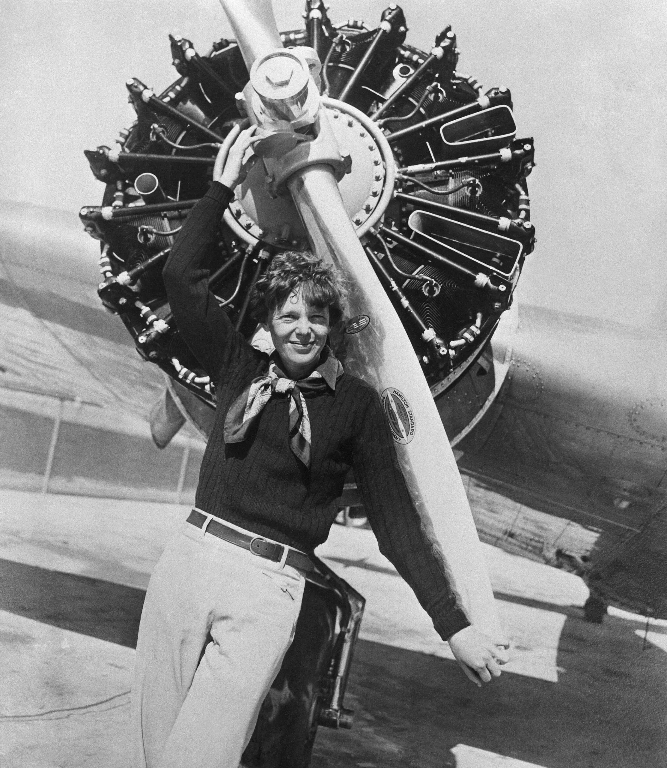 Amelia Earhart leans on the propeller on the right wing engine on her airplane. Earhart and her navigator, Fred Noonan disappeared on a flight over the Pacific Ocean in July, 1937, and neither their plane nor their bodies were ever recovered.