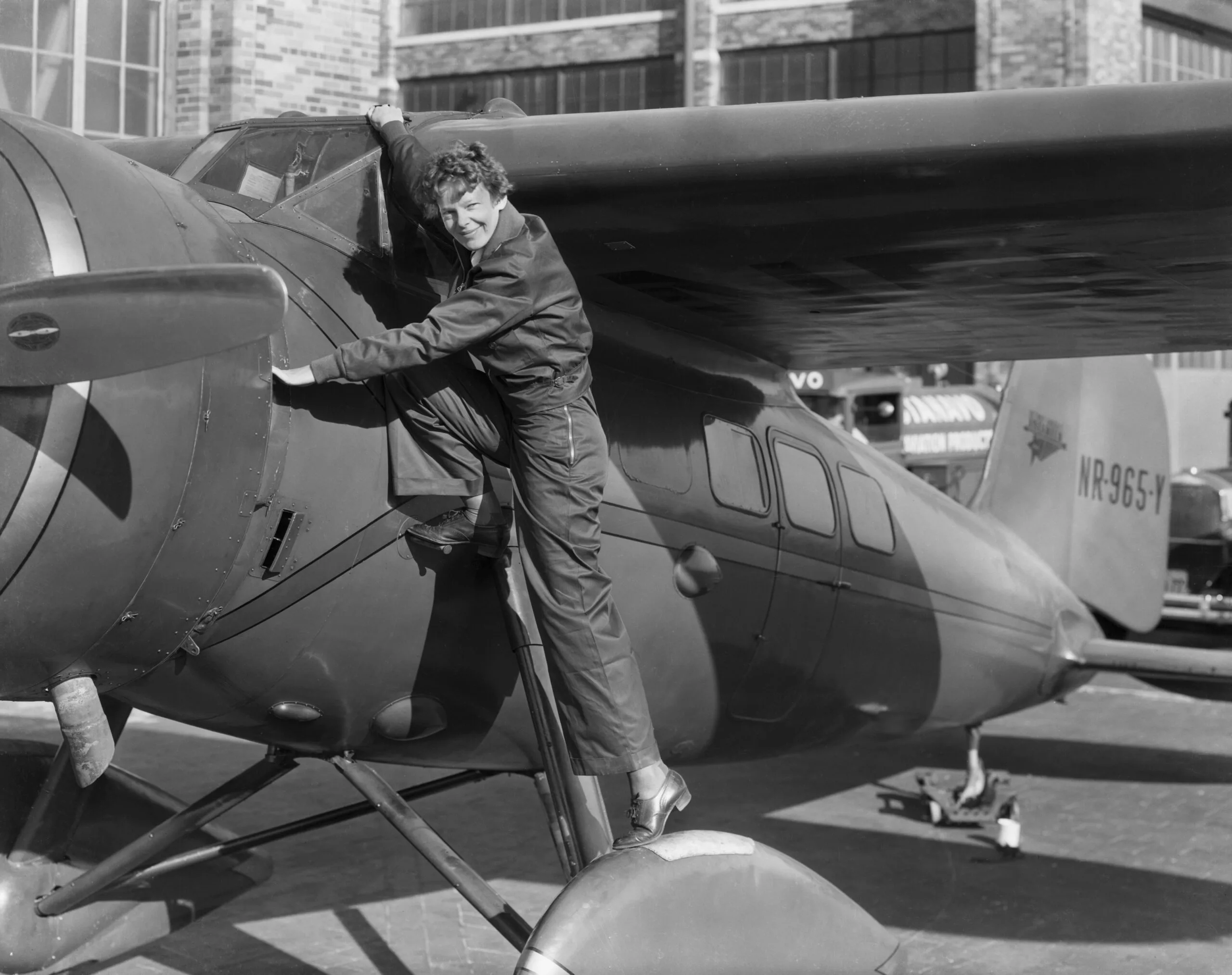 (Original Caption) Amelia Earhart, (1898-1937), first woman to cross the Atlantic Ocean in an airplane. She is shown climbing into the cockpit. Photo: Getty Images