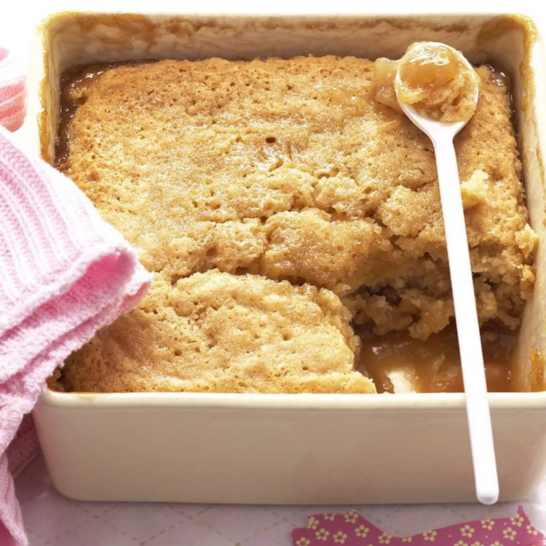 caramel pudding in a square pudding dish with a spoon