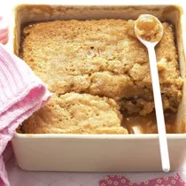 caramel pudding in a square pudding dish with a spoon
