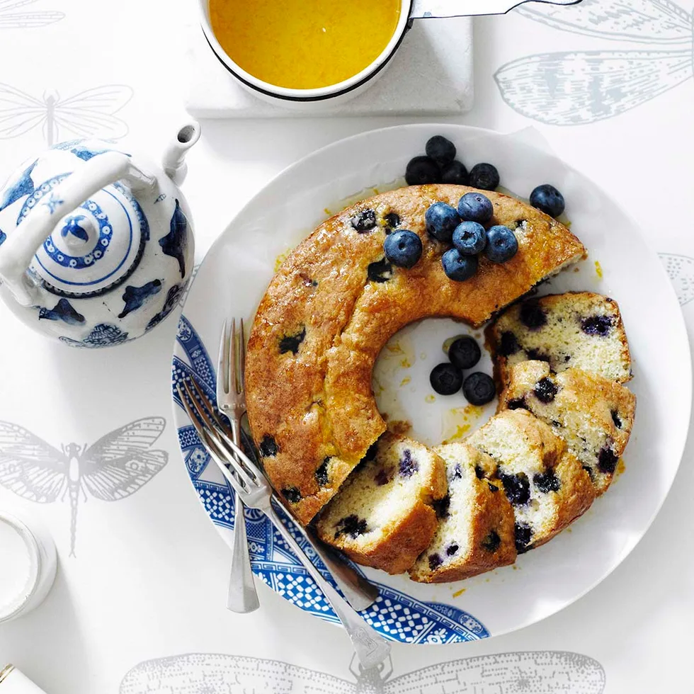 sliced blueberry and orange syrup cake on a plate.