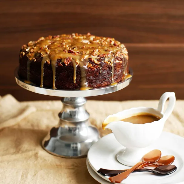 Sticky date pudding cake with caramel sauce on a cake stand