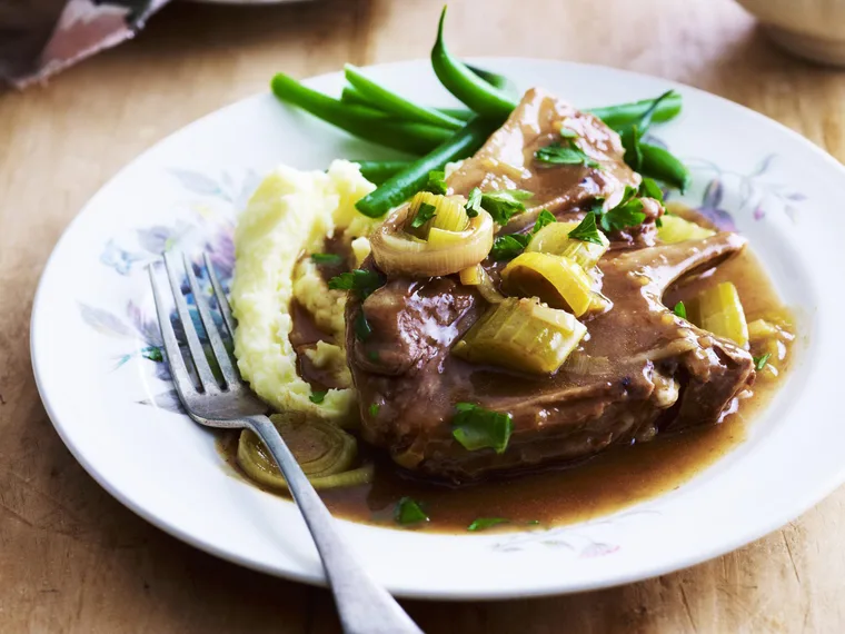 A serve of French Onion Lamb Chops with mashed potatoes and green beans on the side.