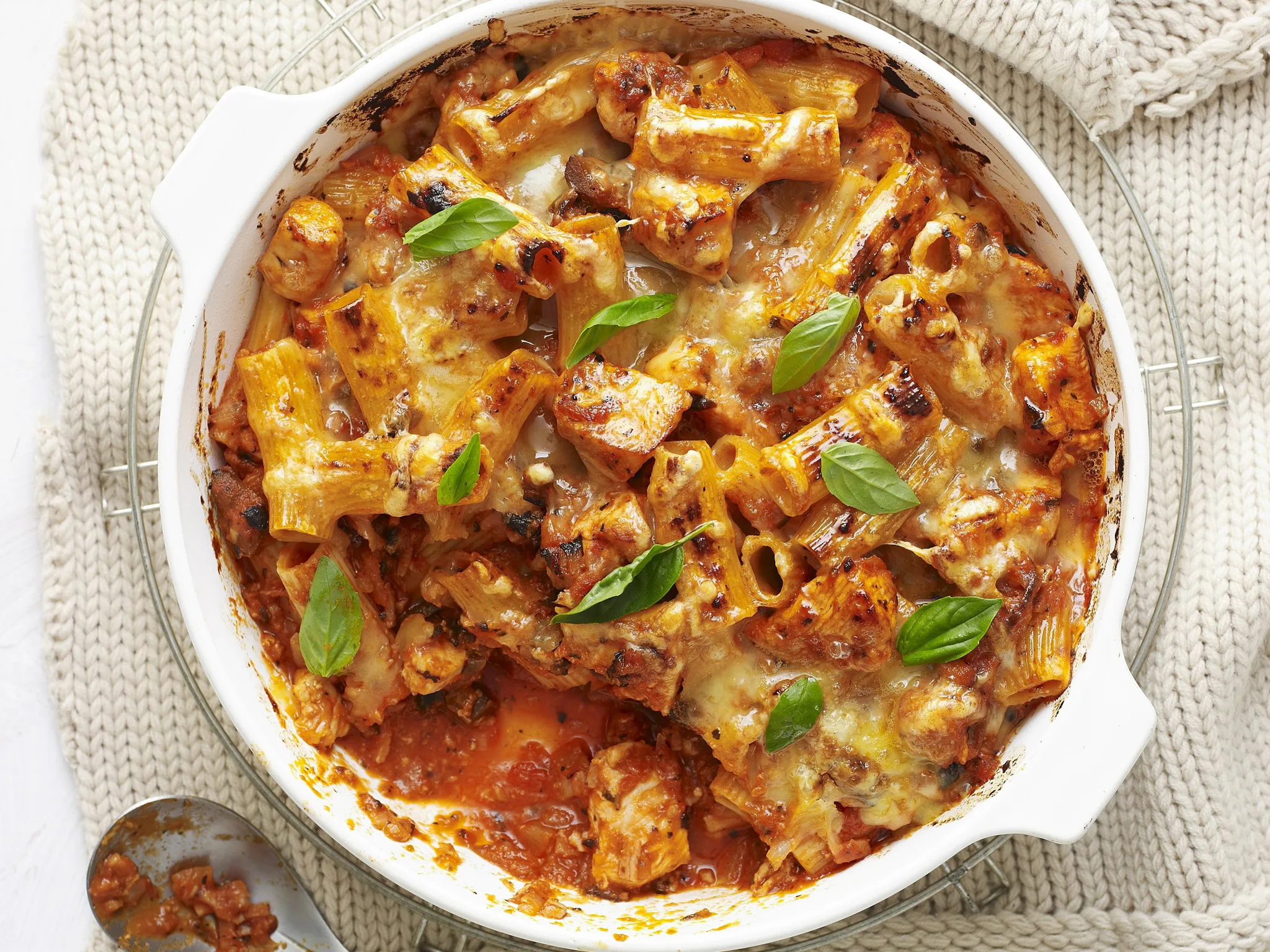 chicken bacon pasta bake topped with fresh basil leaves