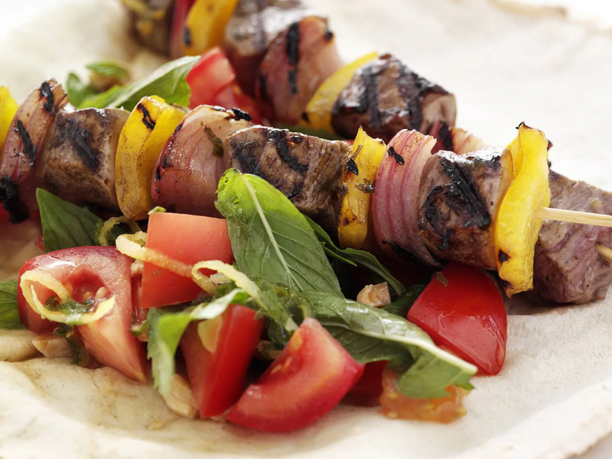 Souvlakia with tomato, almond and mint salad