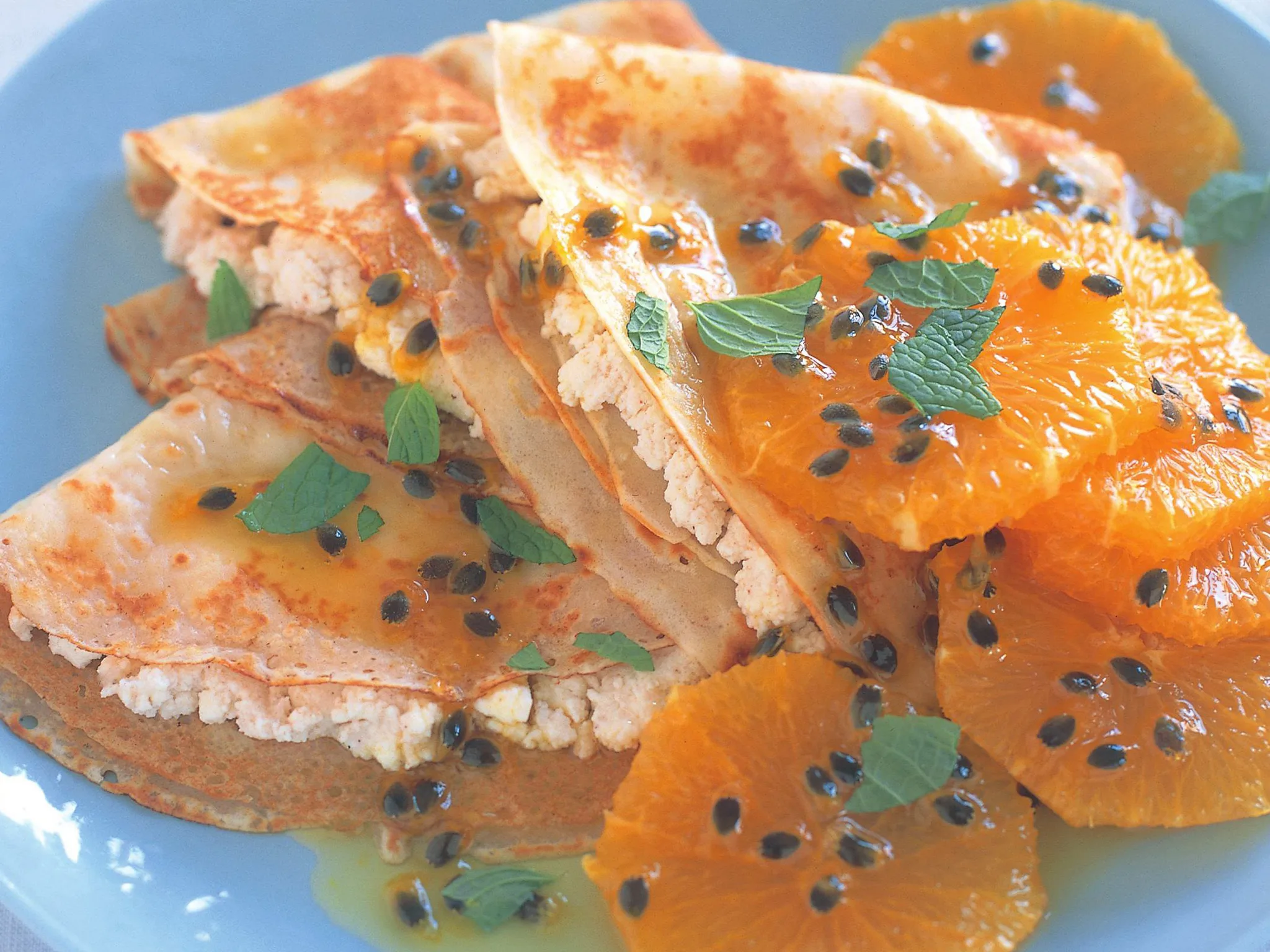 cheese-filled crepe triangles with caramelised oranges