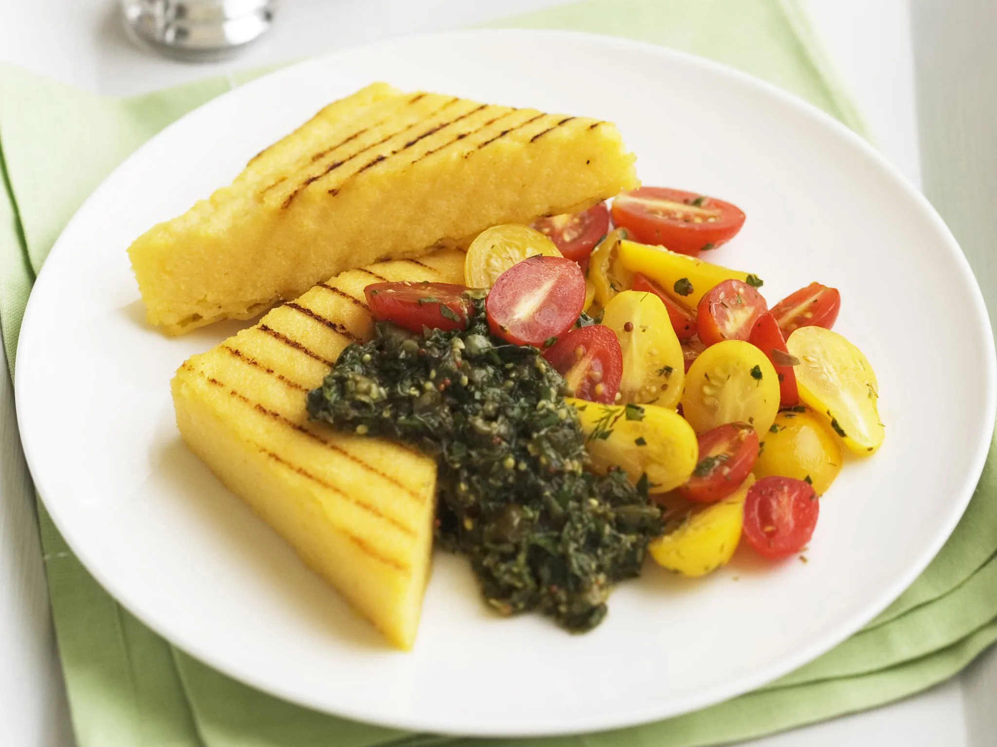 mixed tomatoes on cheesy polenta with dill salsa verde