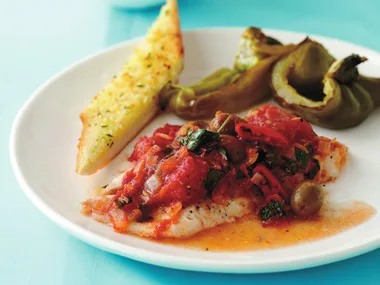 Baked fish with tomatoes, olives and garlic bread