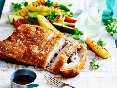 Crispy pork belly with pineapple salad on a platter
