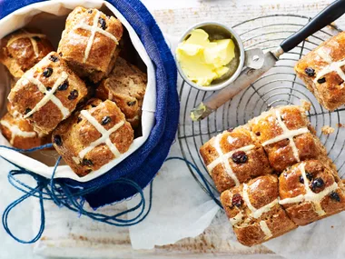 Gluten free hot cross buns on a cake stand and in a bowl